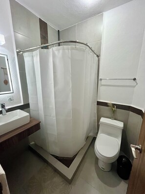 Ein Badezimmer mit Duschvorhang, Toilette und Waschbecken.
