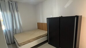 Ein Schlafzimmer mit einem Bett, einem Kleiderschrank und einer Deckenleuchte.