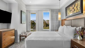 A hotel room with a large bed, a TV, a desk, and a view of the outdoors. - Marriott Vacation Club- large 2 bd 2ba unit (Palm Desert)
