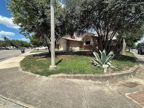 A residential area with a house, a sidewalk, a street, and a utility pole.
