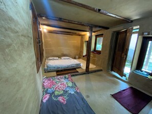 A room with a bed, a window, and a door. - Tranquil 1-bedroom Mud House in charming Bashisht perfect for getaway (Bashisht)