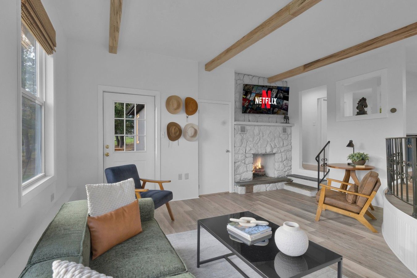 A living room with a fireplace, a television mounted above it, and a sofa with cushions.