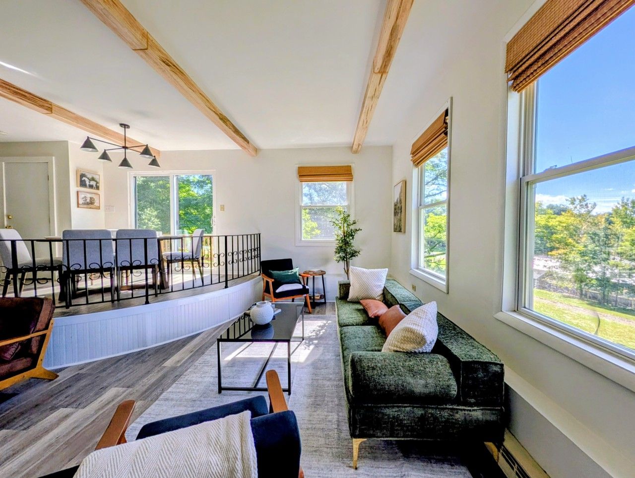 A spacious living room with a large window, a sofa, a coffee table, and a fireplace.