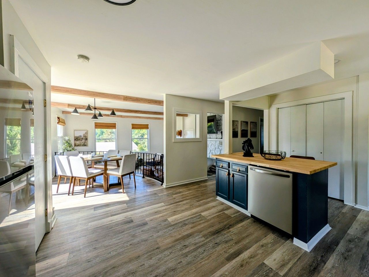 A spacious kitchen with a central island, wooden flooring, and modern cabinetry.