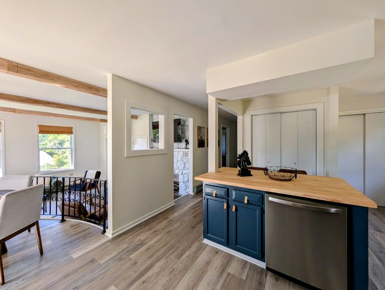 A modern kitchen with a wooden countertop, blue cabinets, and a stainless steel dishwasher.