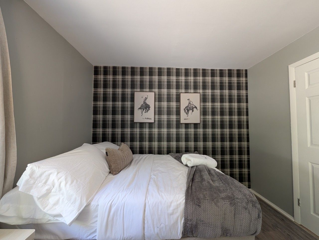 A bedroom with a bed, a pillow, a blanket, and a door.