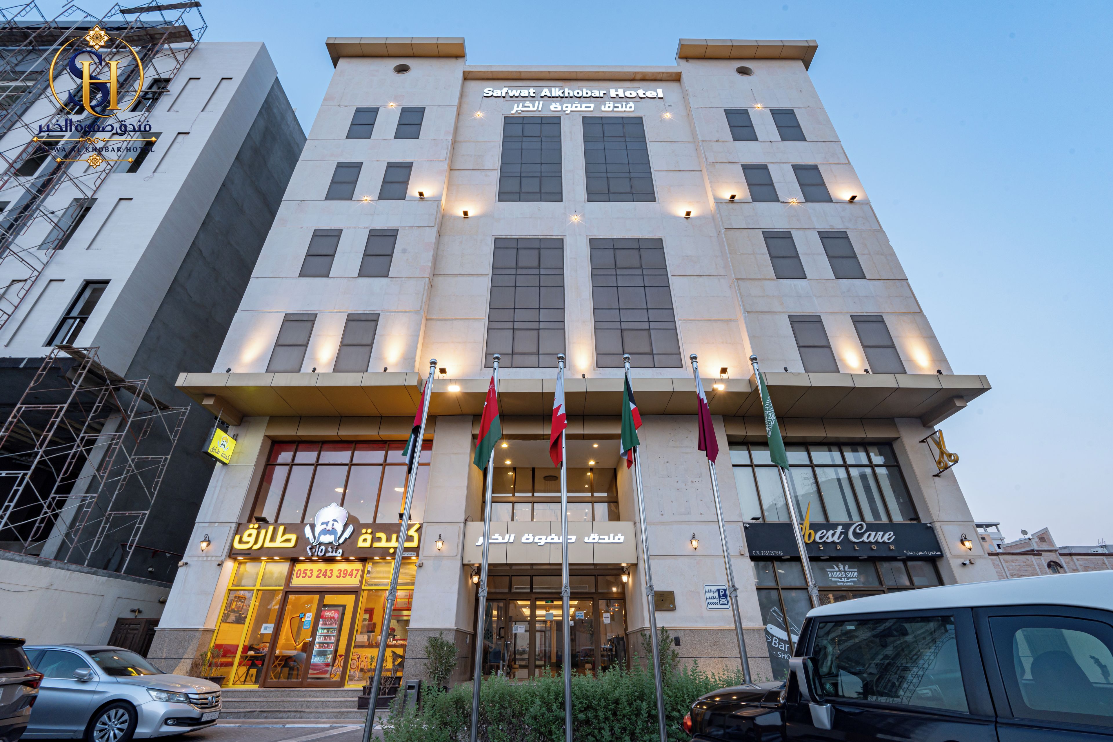 A hotel with multiple floors, a prominent entrance, and flags.