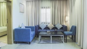 Ein modernes Wohnzimmer mit einer Sofagarnitur, einem Couchtisch und einer Lampe.