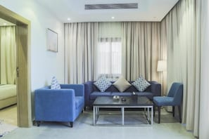 A modern living room with a sofa set, a coffee table, and a lamp. - sfwat alkhobar hotel (alkhobar)