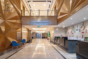 A hotel lobby with a reception desk, seating area, and a view of the parking lot. - sfwat alkhobar hotel (Al Khobar)