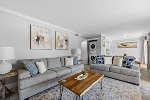 A modern living room with two grey sofas, a wooden coffee table, and a washing machine in the background. - Seascape Villa 2A *Updated*Quiet villa*Beach access* (Miramar Beach)