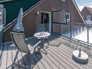Ein Balkon mit Tisch und Stühlen, einem kleinen runden Tisch und einer Wasserspeise.