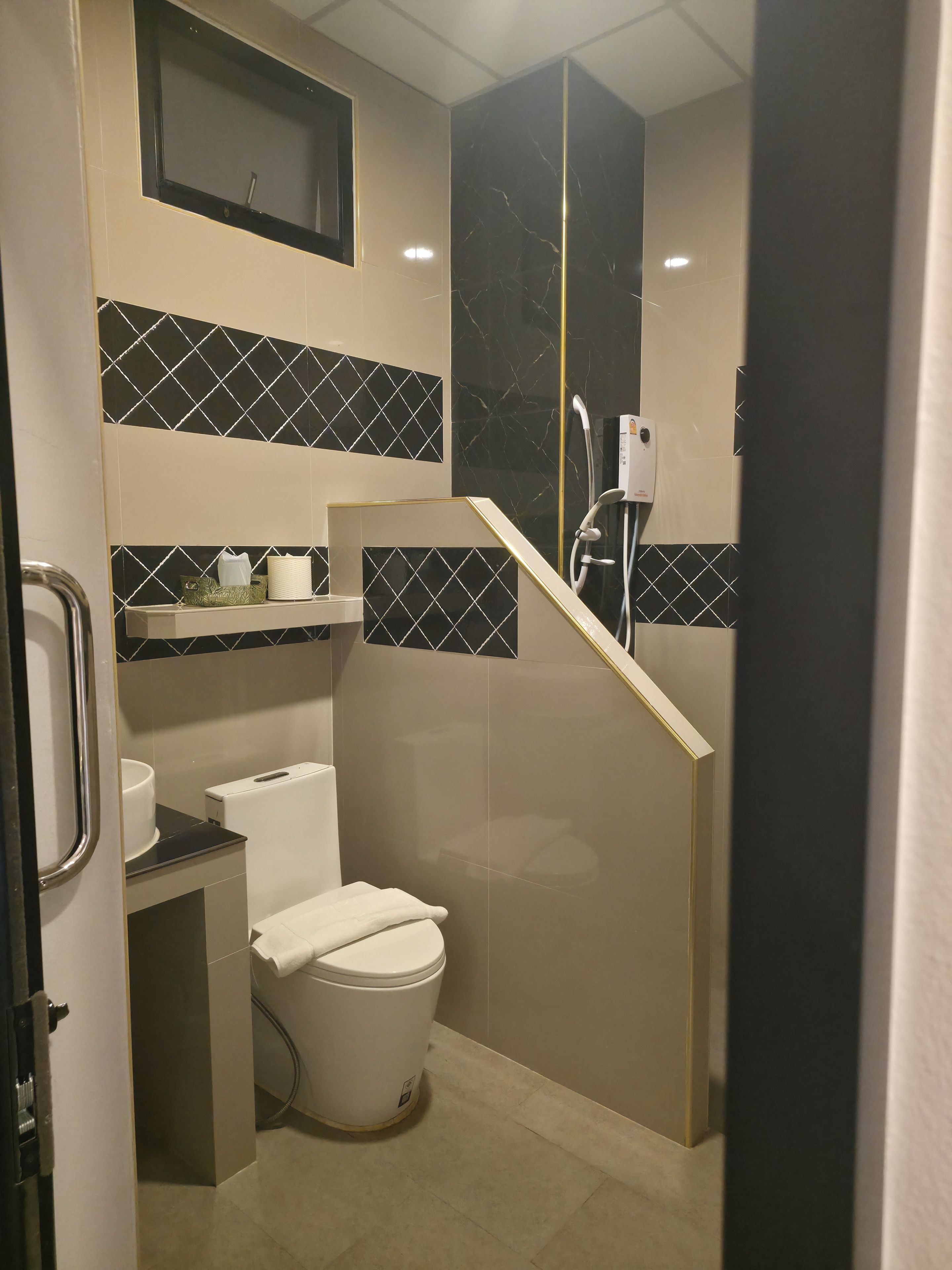 Un baño pequeño con inodoro, lavamanos y cabina de ducha.