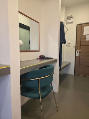 A bathroom with a mirror, a towel rack, a hairdryer, and a sink.