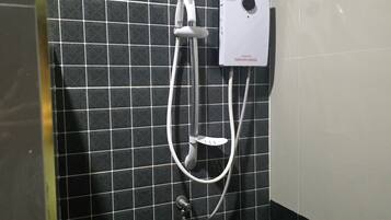 Zona de ducha con un gabinete empotrado en la pared, un cabezal de ducha manual y una manguera de ducha.