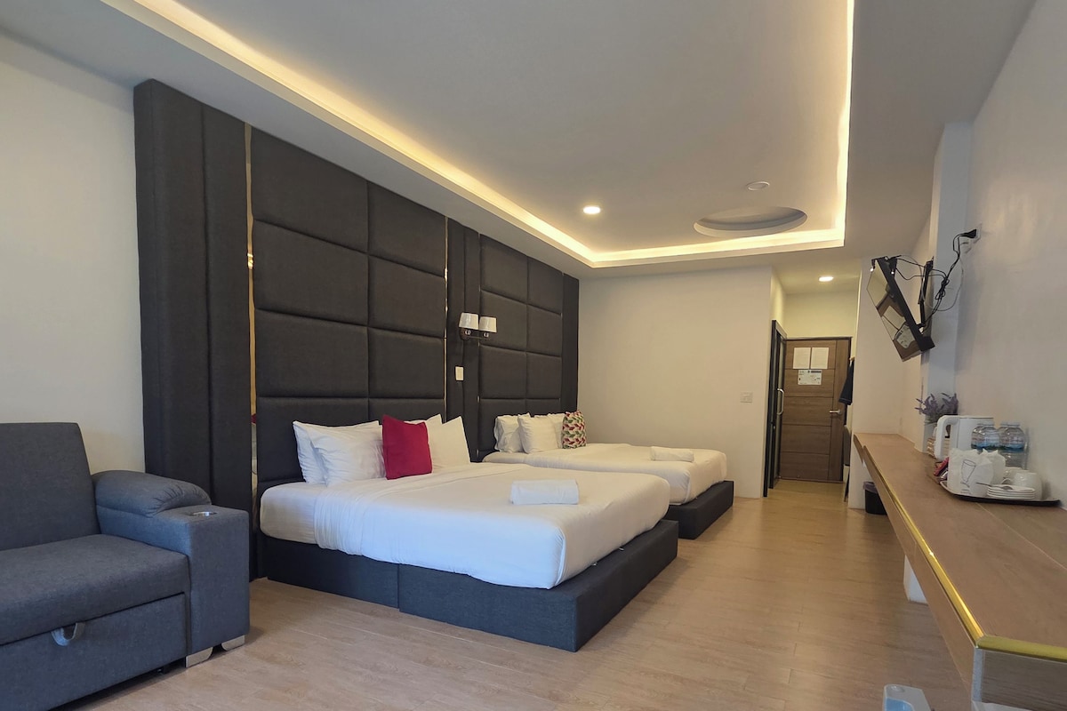 Moderni hotellihuone, jossa on sänky, sohva, työpöytä ja kylpyhuone.