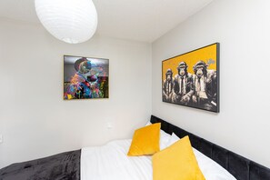 A bedroom with a bed, two paintings, and a white ceiling light. - 1BR Flat in Stockton | Cozy | Near Station (Stockton-on-Tees)