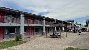 Ein Motel mit zweistöckiger Bauweise, Sitzbereich im Freien und einem überdachten Picknicktisch.
