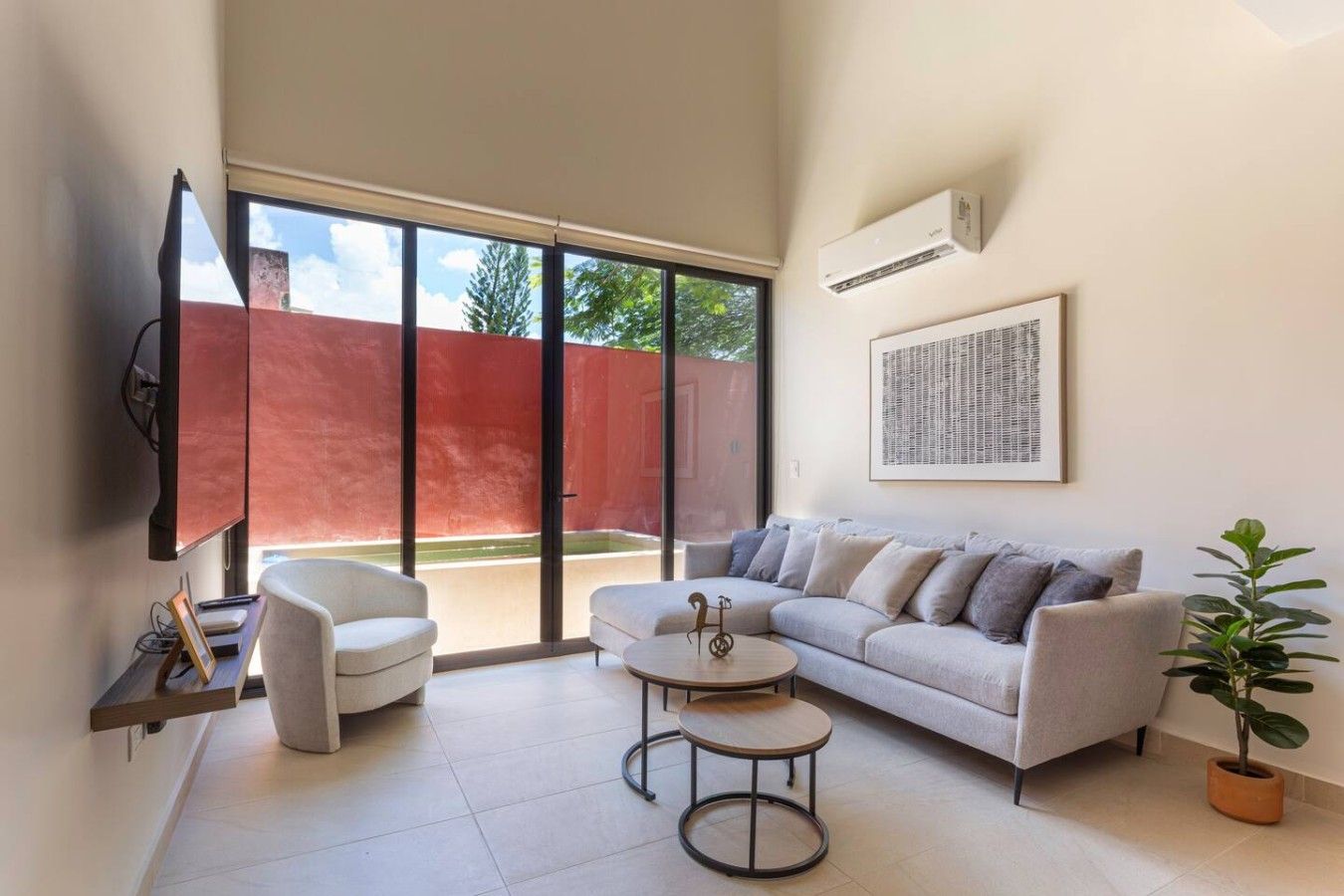 Una sala moderna con sofá, sillón, mesa de centro y televisor.