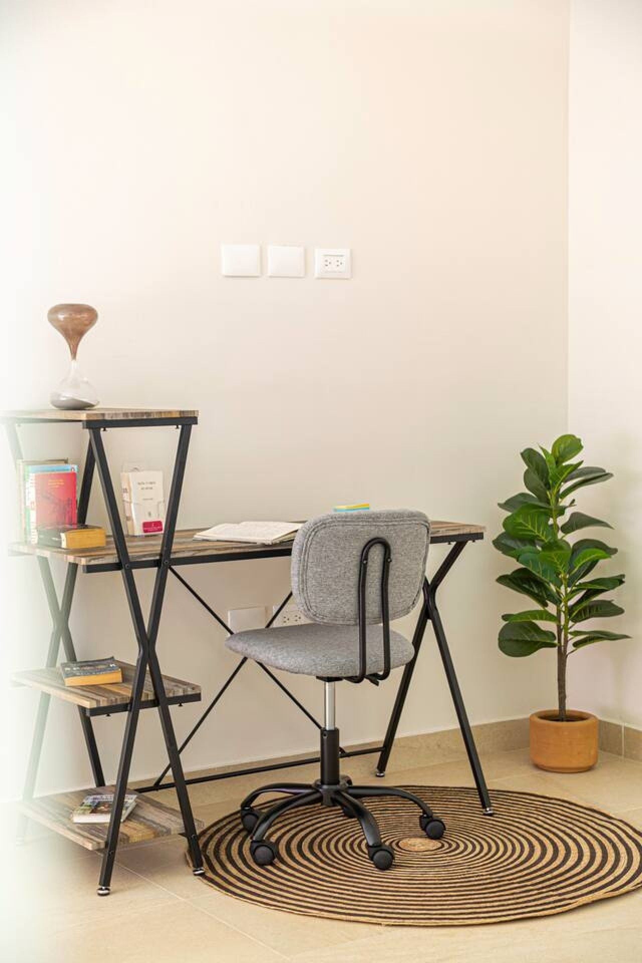 Un espacio de trabajo con escritorio, silla y estantería.