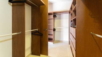 Un vestidor con puertas de madera, estantes múltiples y espacio para colgar ropa.