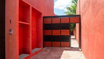 Un estrecho callejón con una pared roja y una puerta de madera.