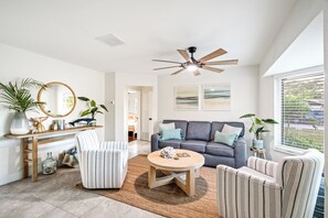 A modern living room with a sofa, armchairs, a coffee table, and a ceiling fan. - Waterfront Oasis • Heated Pool & Spa • Near Beach (Oakland Park)