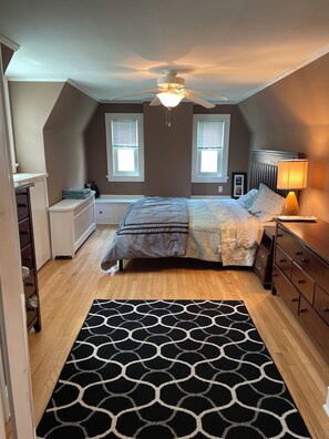 A bedroom with a bed, bedside tables, a ceiling fan, and a window. - 4BR Vilas House near Camp Randall, Meriter & UW Hospitals (Madison)