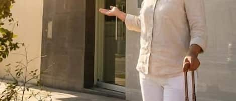 A person standing in front of a building with a sign that reads 'Villa del Sol Hotel'.