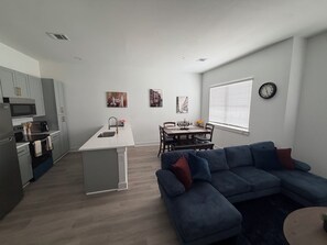 A modern apartment with a kitchen, dining area, and living room. - Katy Comfort Townhome (Katy)