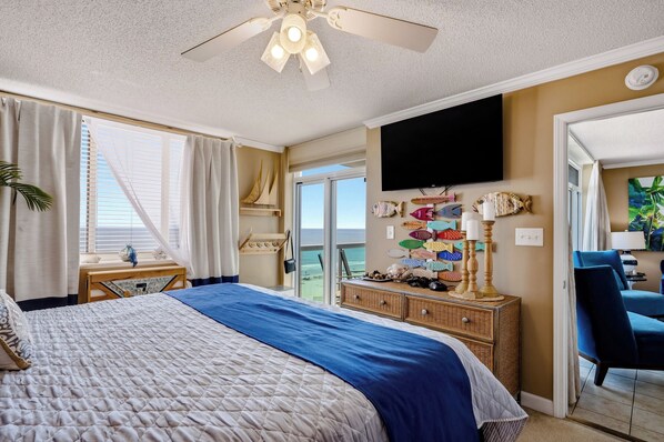 Ein Hotelzimmer mit Bett, Fernseher, einem Balkon mit Blick und einem dekorativen Wandbild mit Fischen.