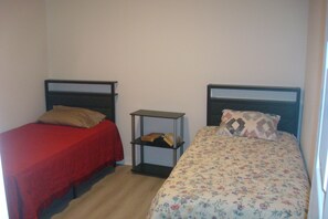 A small room with two single beds, each with a different style of headboard and bedding. - Clean, comfortable, quiet and affordable accommodation in Rosenberg (Rosenberg)