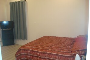 A bedroom with a bed, a television on a stand, and a curtain. - Clean, comfortable, quiet and affordable accommodation in Rosenberg (Rosenberg)