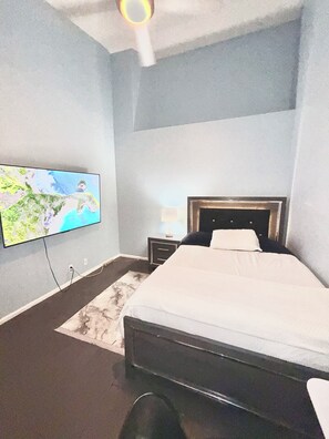 A bedroom with a bed, a nightstand, a lamp, and a television mounted on the wall. -  Centrally located room in Glendale (Glendale)