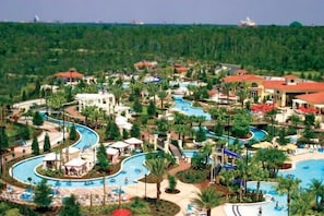Ein Resort mit mehreren Schwimmbecken, Palmen und Hotelgebäuden.