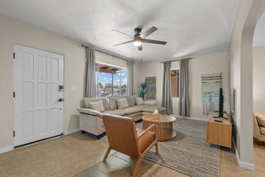 A spacious living area with a sofa, a coffee table, a chair, and a ceiling fan. - Highland Villa  Near U of A Downtown Tucson (Tucson)
