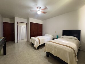 A bedroom with two beds, a ceiling fan, and a wardrobe. - Sunsets & Serenity at Playa Escondida | 2BR Beachfront Getaway (Mazatlan)