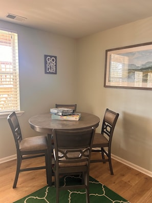 A dining area with a round table, four chairs, and two framed pictures on the walls. - New listing discount! Sunny Shores on Hartwell- Dock, kayaks, pedal boat, games (Martin)