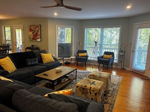A living room with a sofa, armchairs, a coffee table, ottomans, a floor lamp, and a tripod. - New listing discount! Sunny Shores on Hartwell- Dock, kayaks, pedal boat, games (Martin)