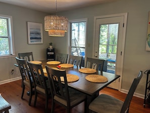 A dining area with a wooden table, eight chairs, woven placemats, and a water dispenser. - New listing discount! Sunny Shores on Hartwell- Dock, kayaks, pedal boat, games (Martin)