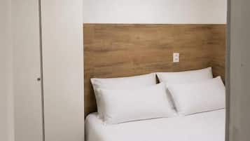 Ein Schlafzimmer mit einem Bett, einem Holz-Kopfteil und einem weißen Kleiderschrank.