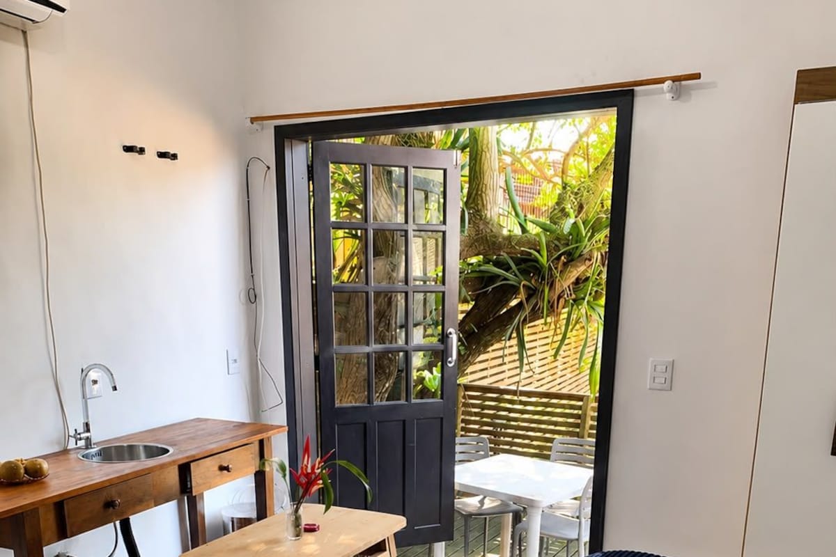 Une chambre à coucher de taille modeste, comprenant un lit, un petit bureau et une fenêtre.