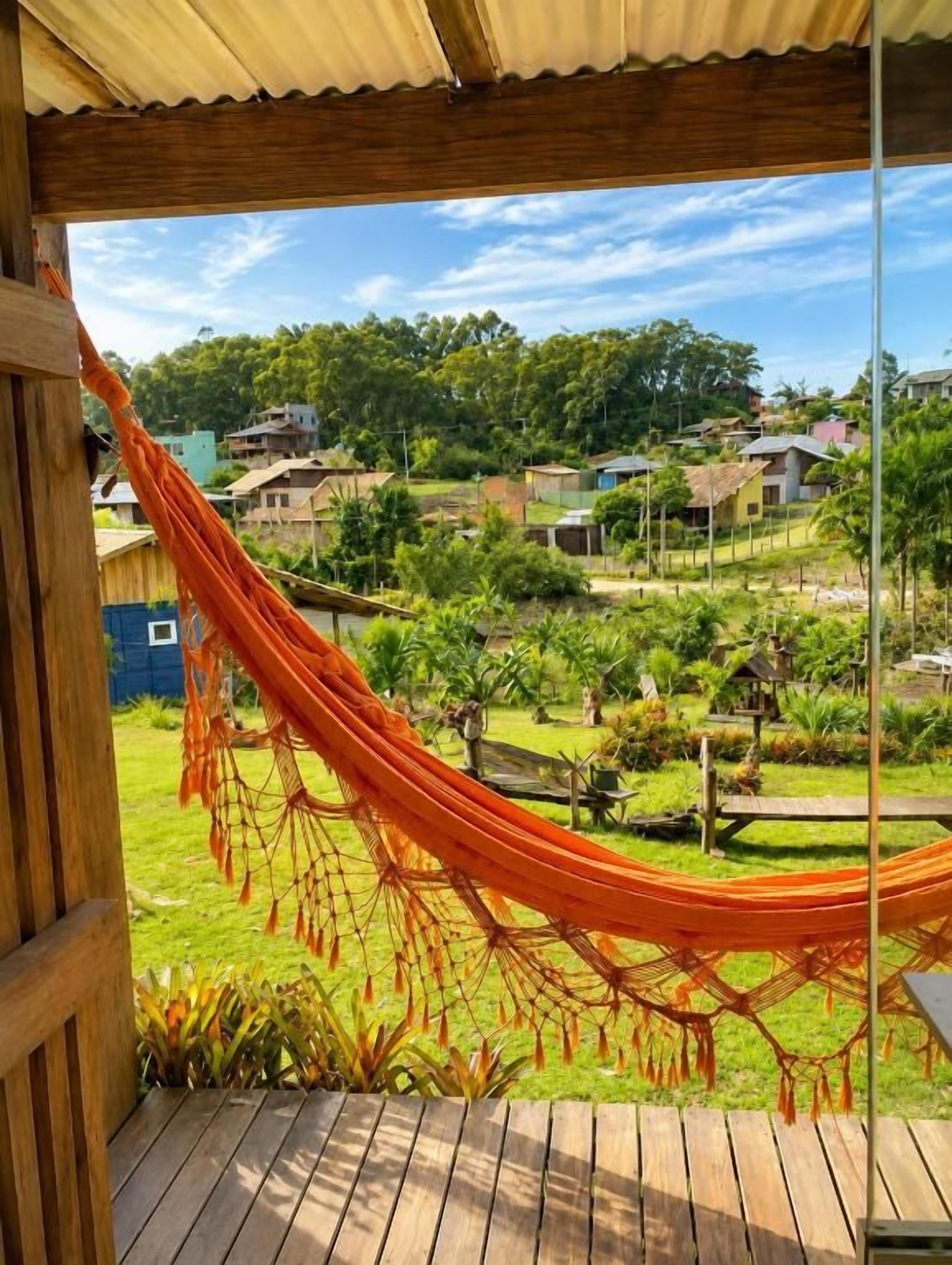 Una hamaca en una terraza de madera con vista a una zona residencial.