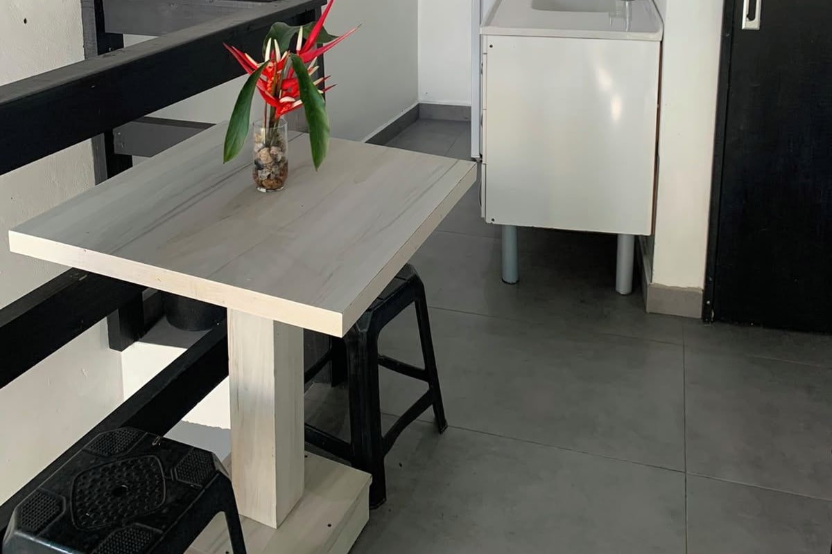 Une cuisine compacte équipée d’un évier, d’un plan de travail et d’un appareil de climatisation fixé au mur.
