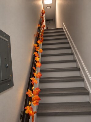 Eine Treppe mit Lichterketten und Herbstlaub.