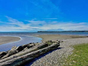 A beach with pebbles, a large log, and a clear blue sky. - GB  102: Beautiful water view! Great Birch Bay location, free Wi-Fi. (Birch Bay)