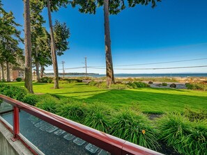 A landscaped area with a paved path, trees, and a view of the ocean. - GB  102: Beautiful water view! Great Birch Bay location, free Wi-Fi. (Birch Bay)