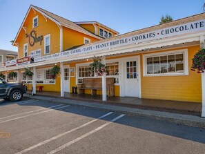 Ein gelbes Gebäude mit einer Schaufensterfront, auf der 'The Shop' und 'Candy Shop' steht.