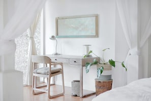 A bedroom with a bed, a desk, a chair, a lamp, and a plant. - 752 Ocean Ave  Unit A & B (Wells)