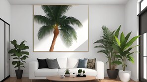 A modern living room with a white sofa, a coffee table, and large potted plants. - 752 Ocean Ave  Unit A & B (Wells)
